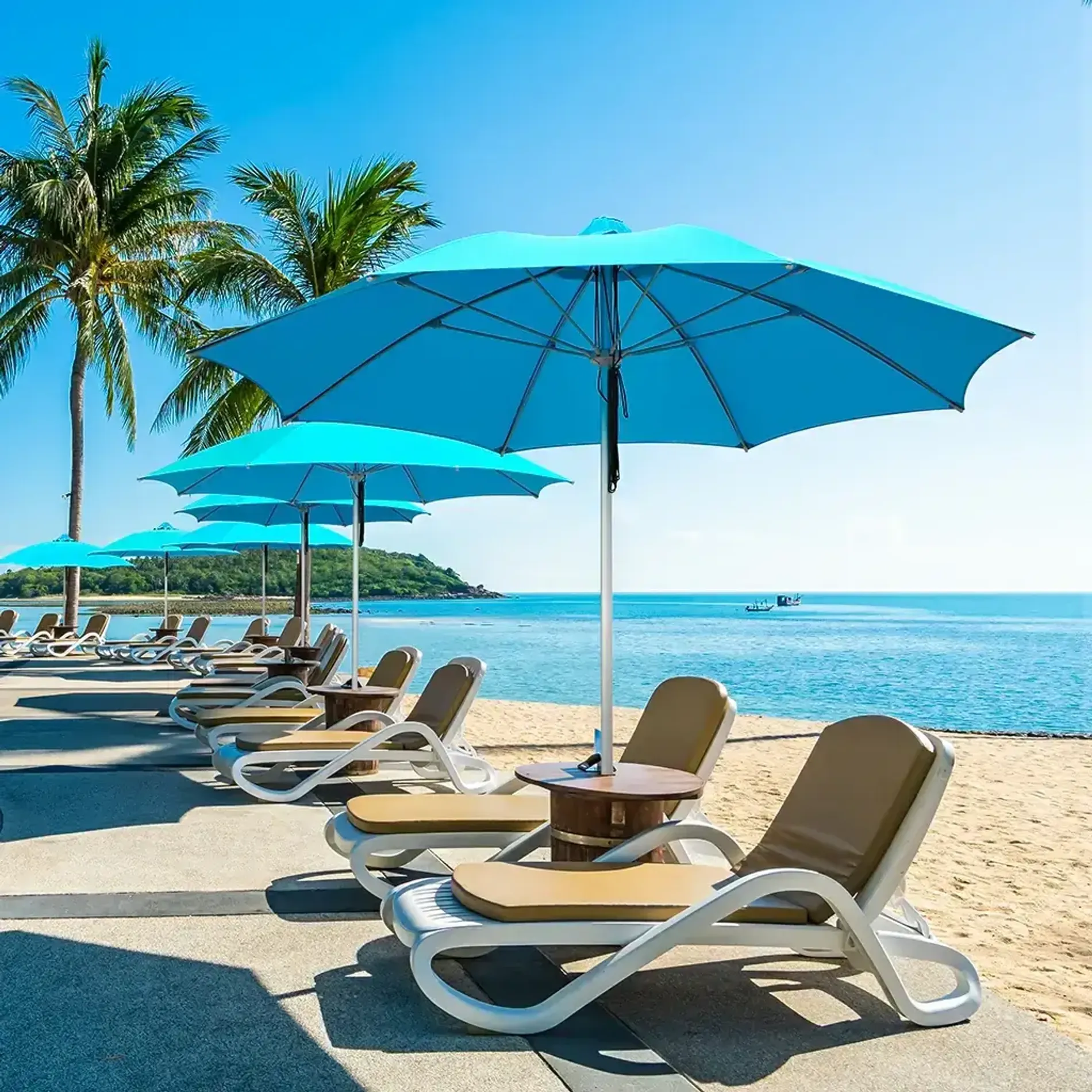Blue Santorini patio umbrellas on a beachside lounge setting with sunbeds and ocean view.
