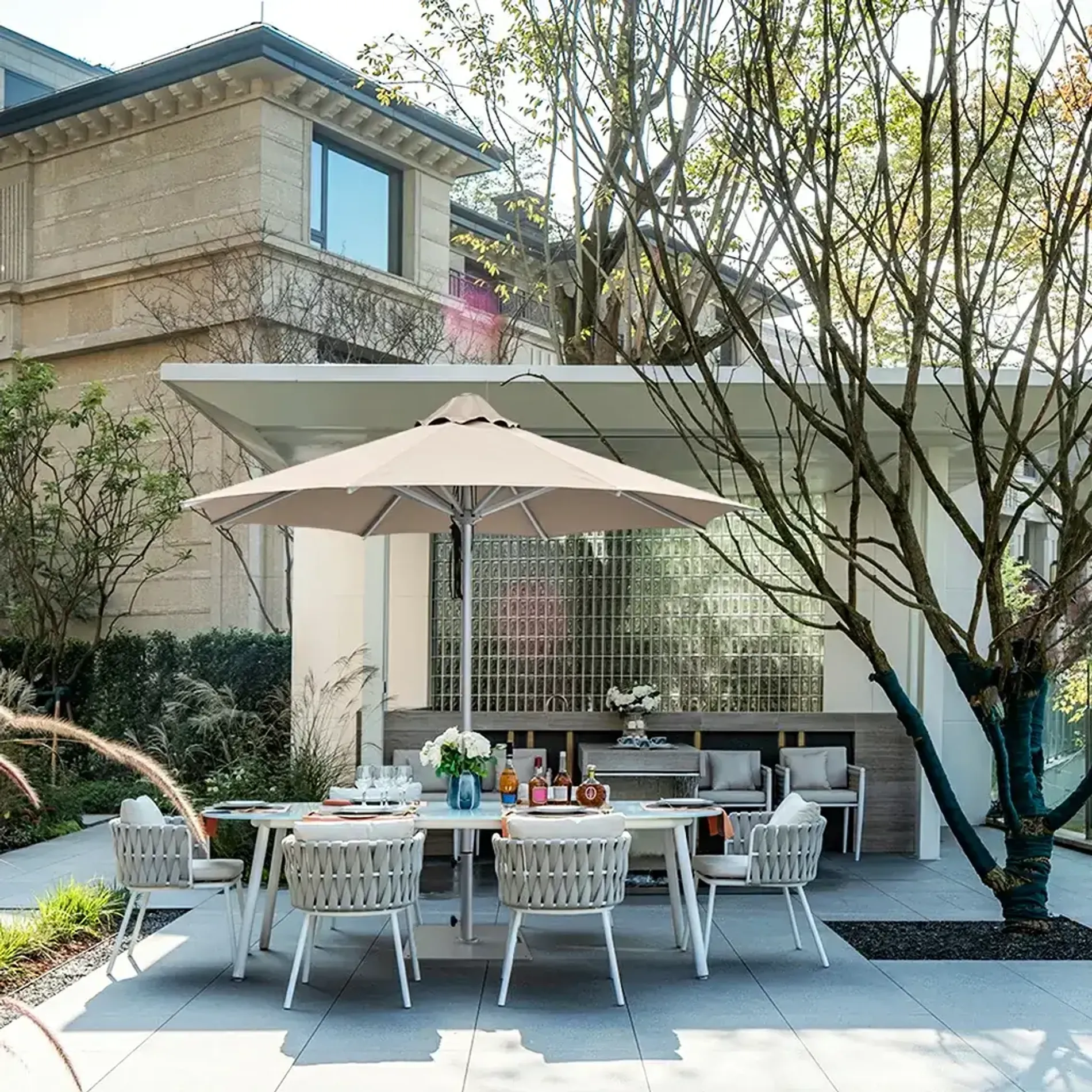 Santorini patio umbrella in a modern backyard outdoor dining area with table and chairs.