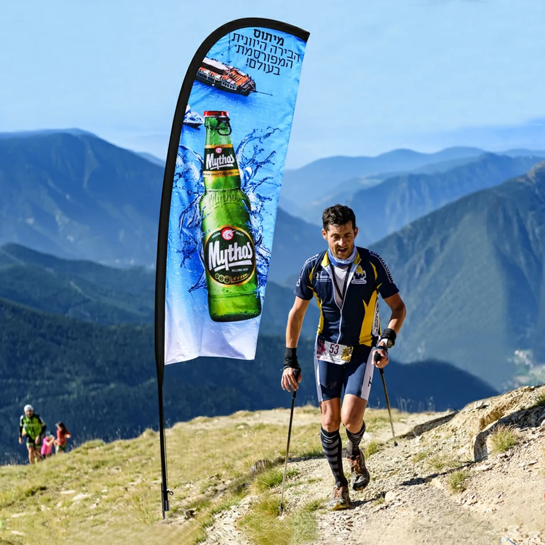 Feather flag in outdoor usage scenario, the flag fluttering in the wind atop a flagpole.