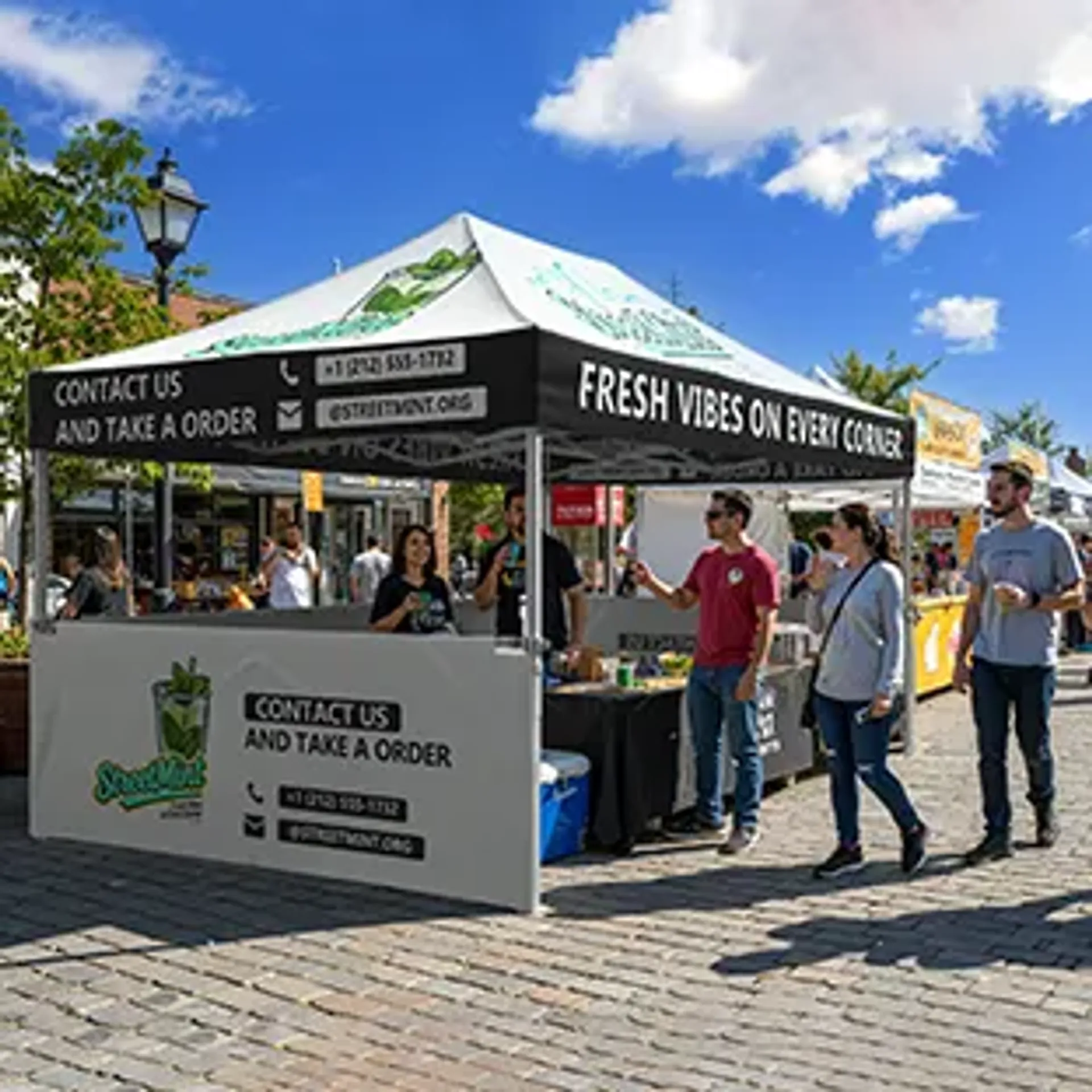 A custom printed pop-up tent serving as a beverage vendor booth for "StreetMint" at an outdoor street festival, featuring branded graphics and contact information on the canopy valance and half walls.