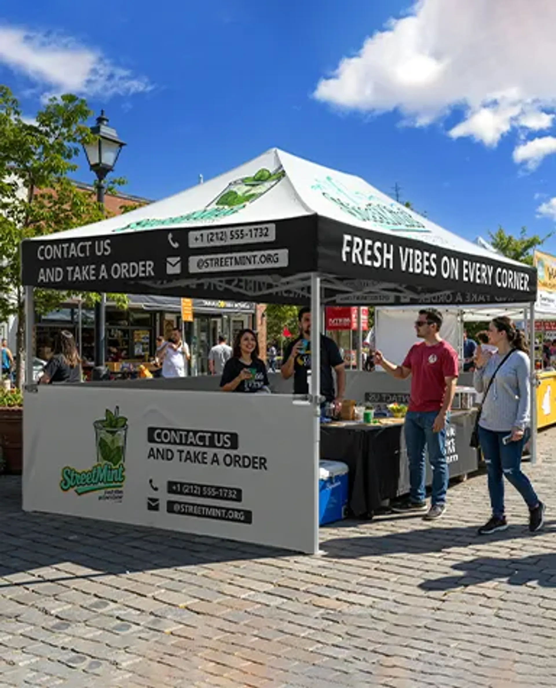 A custom printed pop-up tent serving as a beverage vendor booth for "StreetMint" at an outdoor street festival, featuring branded graphics and contact information on the canopy valance and half walls.