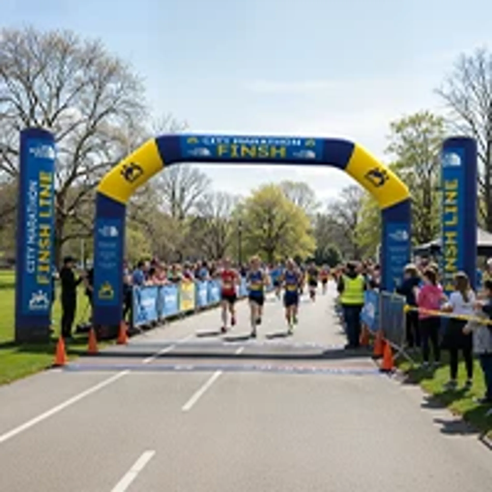 Custom inflatable finish line archway in blue and yellow used for an outdoor city marathon running event