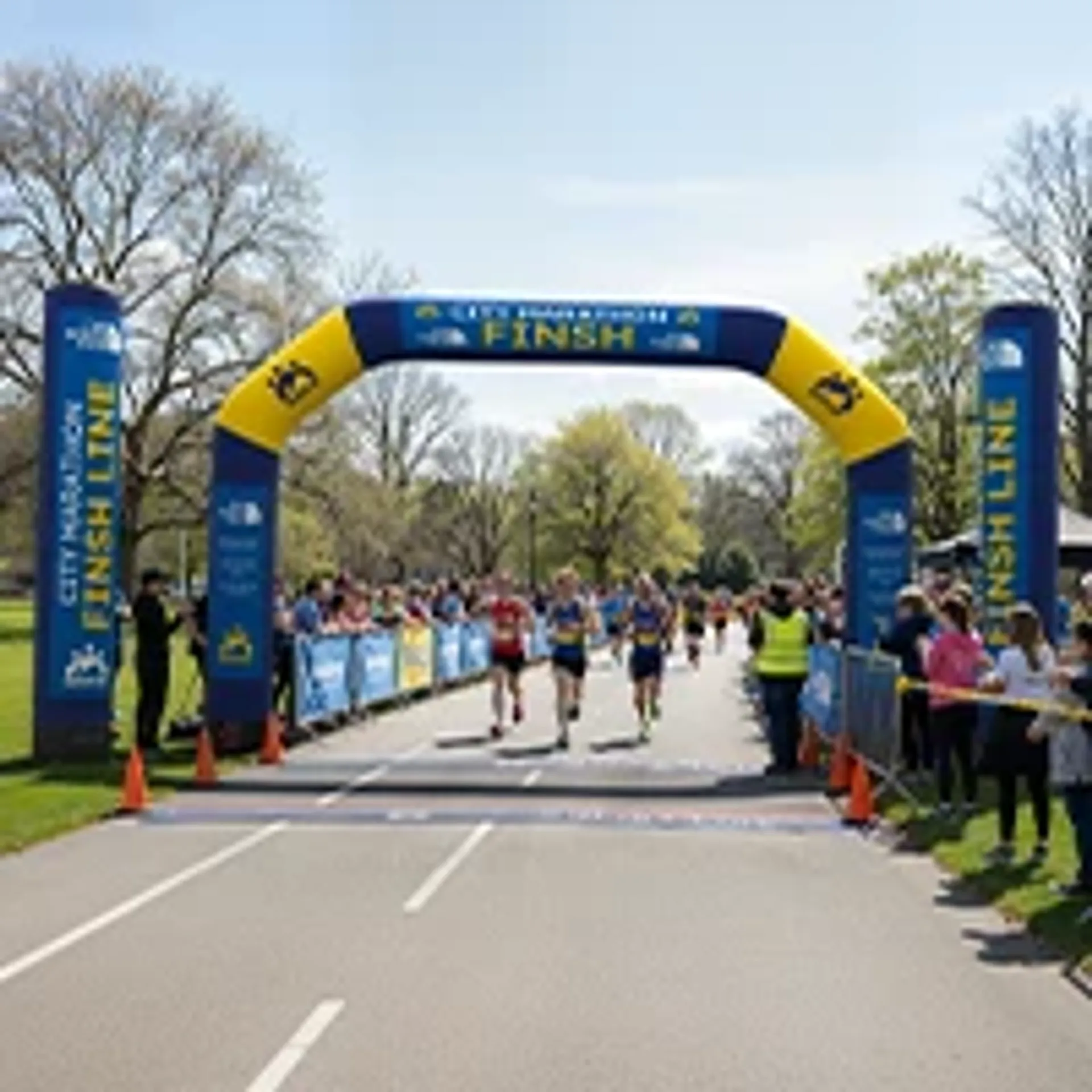Custom inflatable finish line archway in blue and yellow used for an outdoor city marathon running event