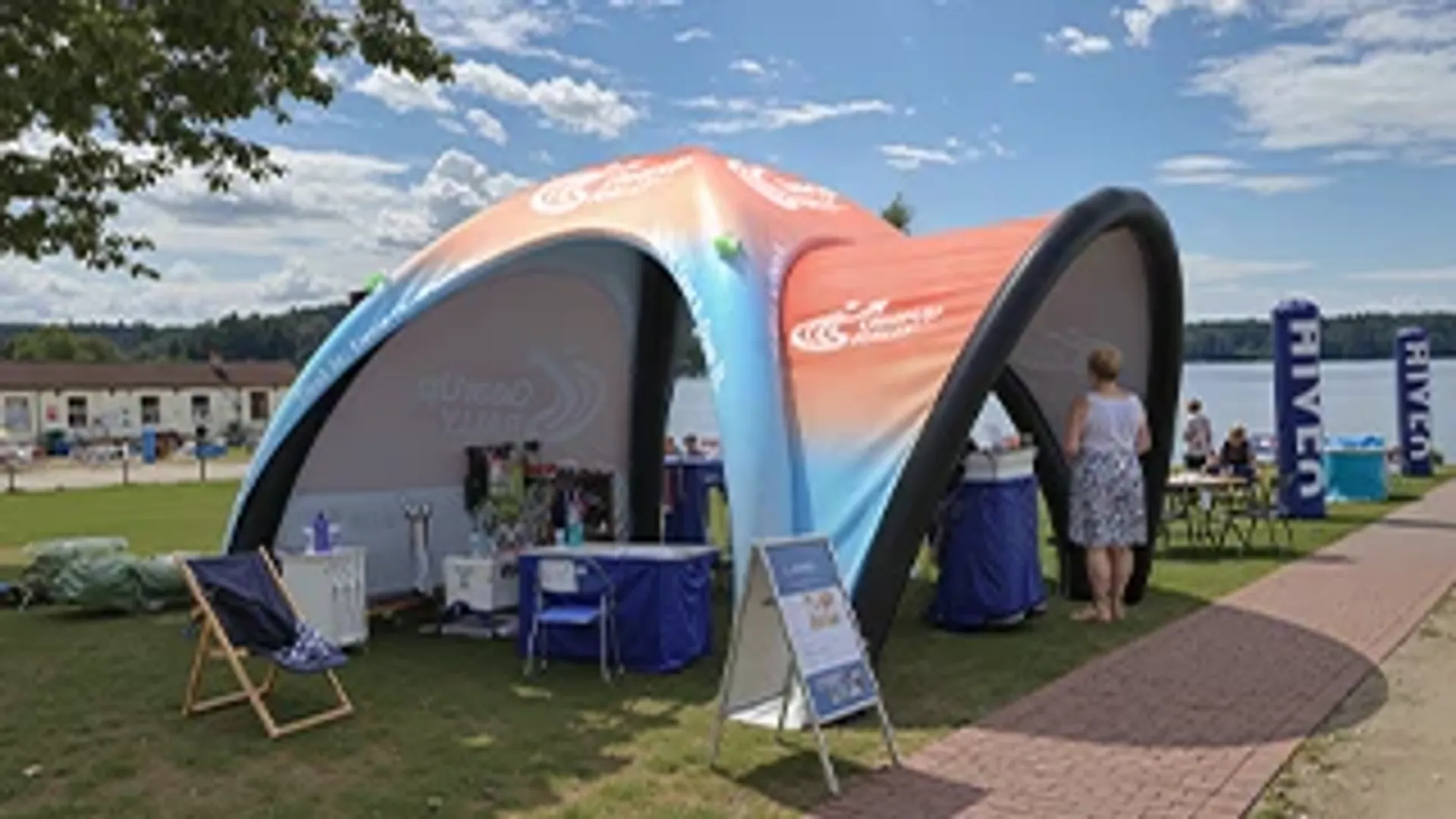 Custom printed inflatable dome tent used as an outdoor registration and information booth for a lakeside sports rally