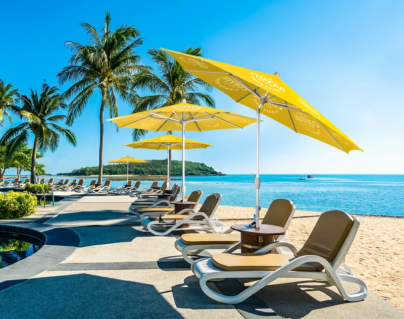 A large tilt patio umbrella casting shadows on a beach