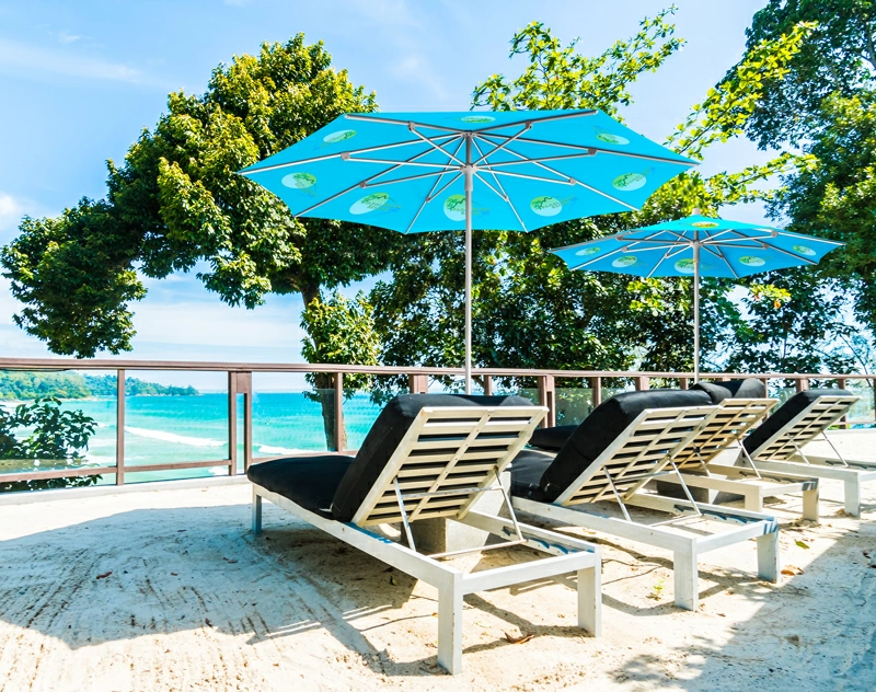 A picturesque outdoor dining area, adorned with a variety of colorful market umbrellas providing shade for the lounge chairs