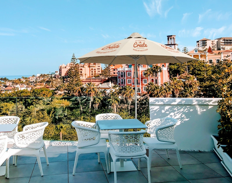 A khaki custom market umbrella shades the sun in the lounge area on the balcony