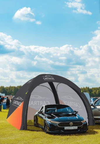 Custom inflatable dome tent used as a car display booth at an outdoor auto show.
