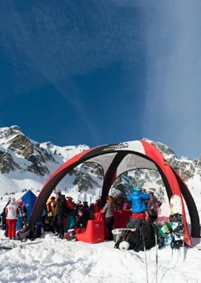 Custom inflatable dome tent used as a branded shelter at a snowy mountain ski event.