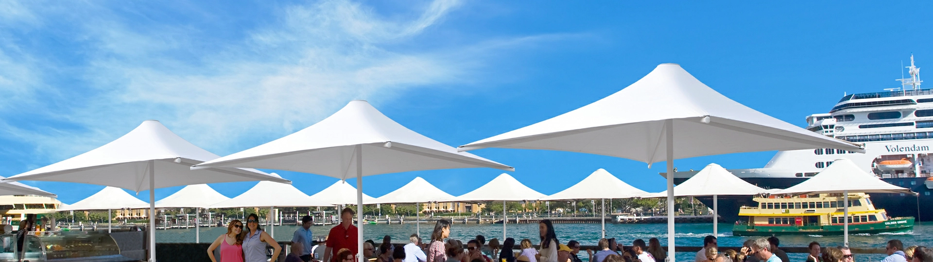 large Catalina umbrellas are set up on an outdoor deck for shade and shelter